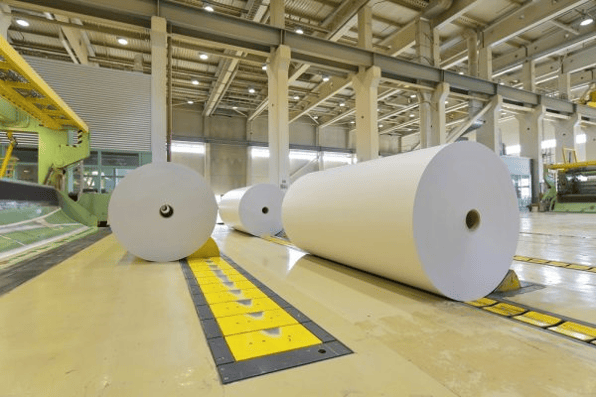 Large rolls of recycled fibre material in an industrial paper processing facility supported by efficient mixing processes.