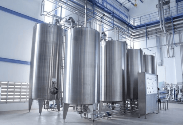 Six large metal canisters being used in a pharmaceutical plant using static mixers to ensure the industrial process is more cost efficient.