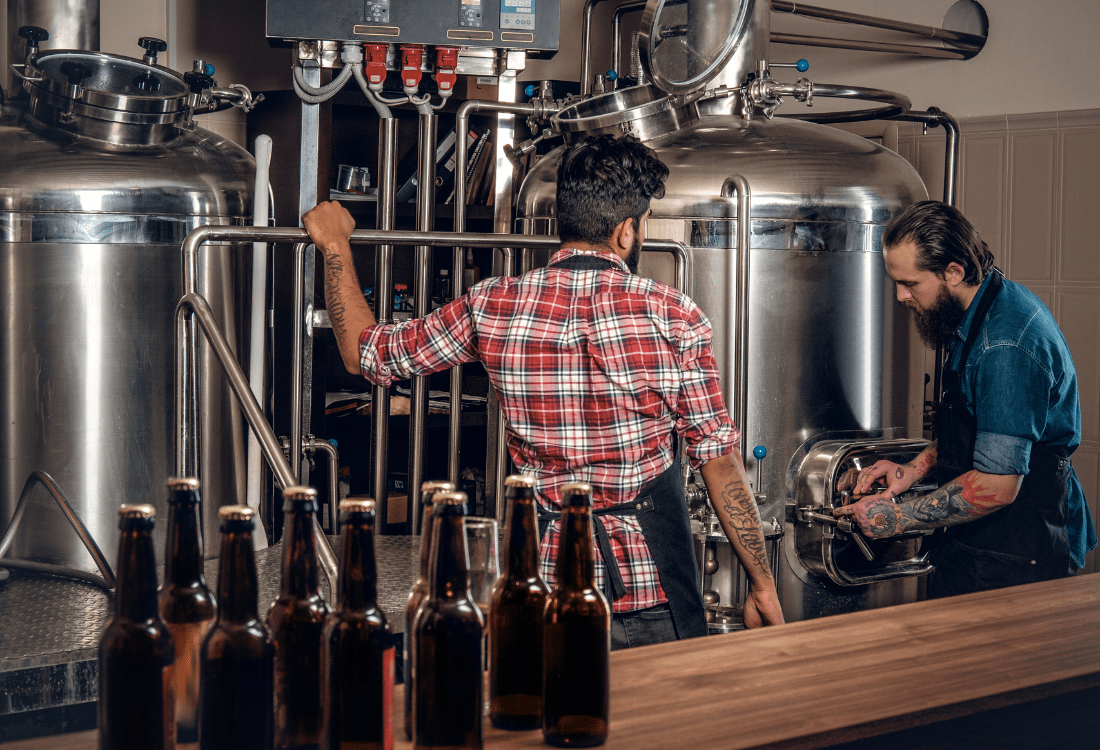 Two men brewing beer with the assistance of Statiflo static mixers in the brewing process. 