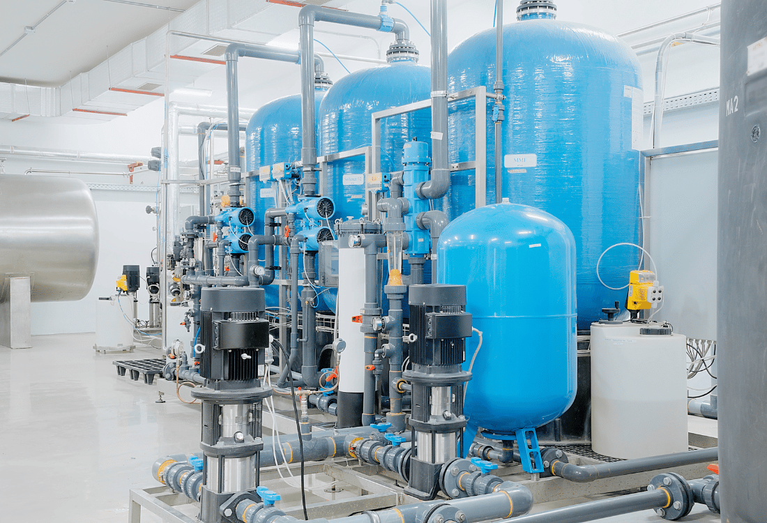 Three large tanks connected to pipes in a water desalination facility using the appropriate static mixers for different fluids 